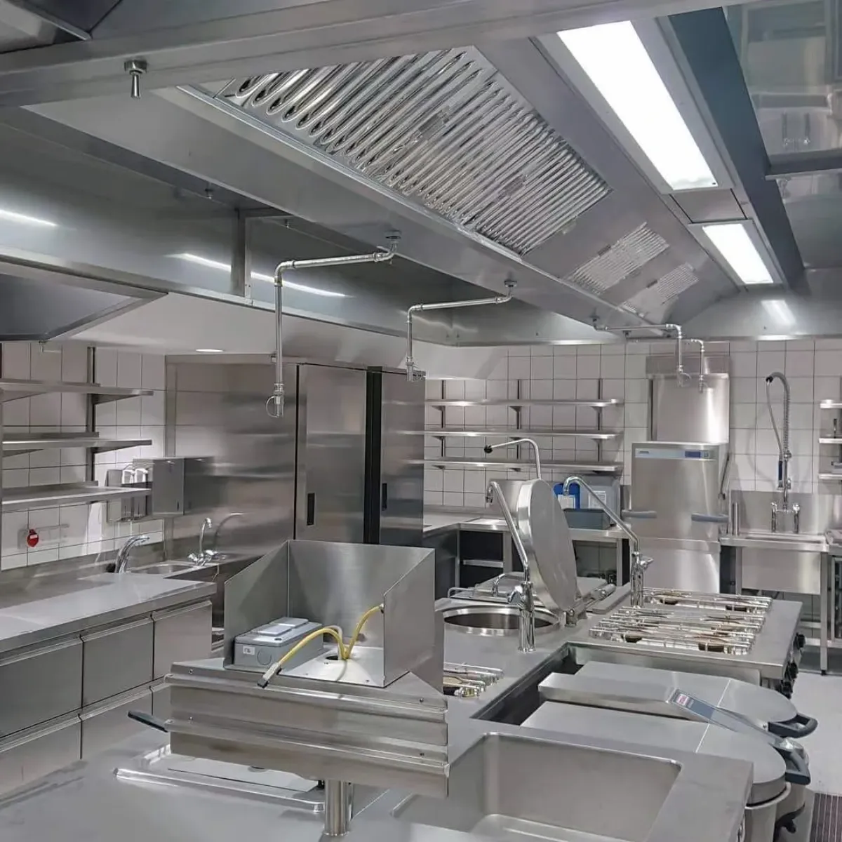 Stainless steel commercial kitchen ventilation hoods with integrated fire suppression system nozzles and ductwork