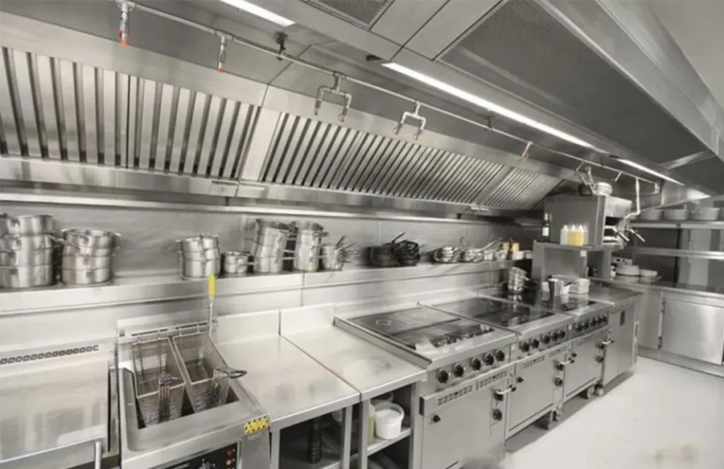 Automatic fire suppression nozzles installed under a commercial kitchen hood