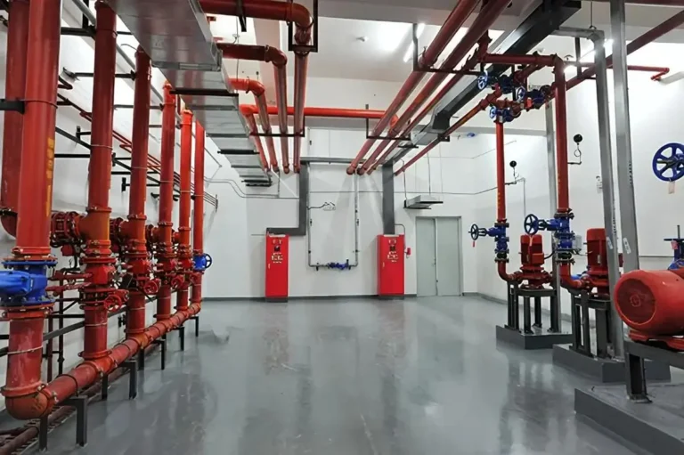 Red piping manifold and foam concentrate tank assembly for an industrial fire suppression pump station serving heavy oil and mining facilities
