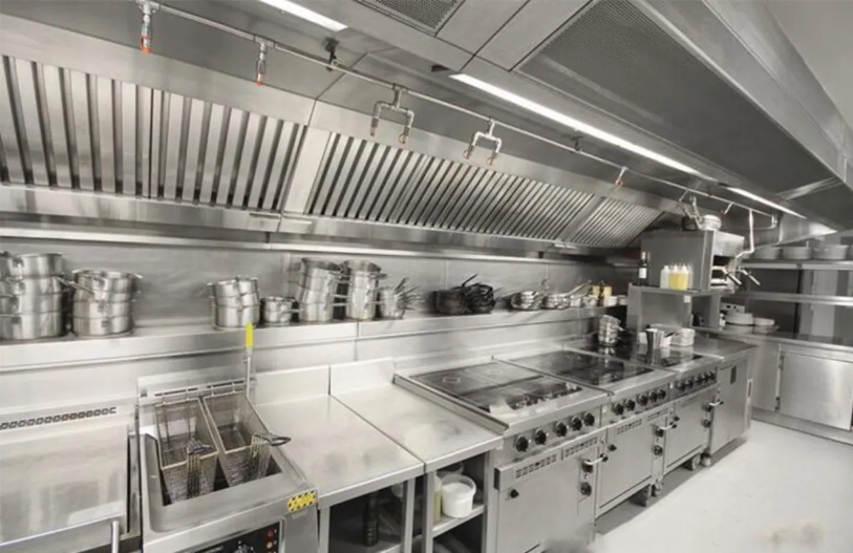 Automatic wet chemical fire suppression nozzles under a commercial kitchen exhaust hood for UL 300 grease fire protection