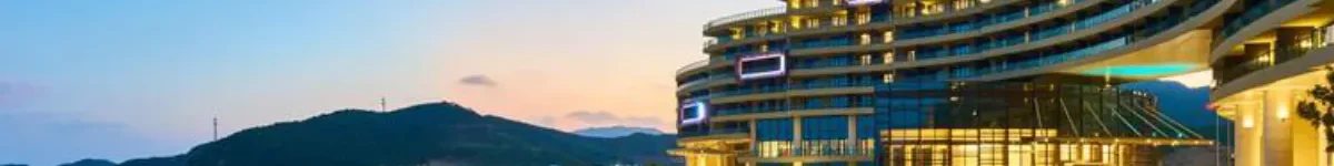 Luxury beach resort with illuminated architecture and pools at dusk